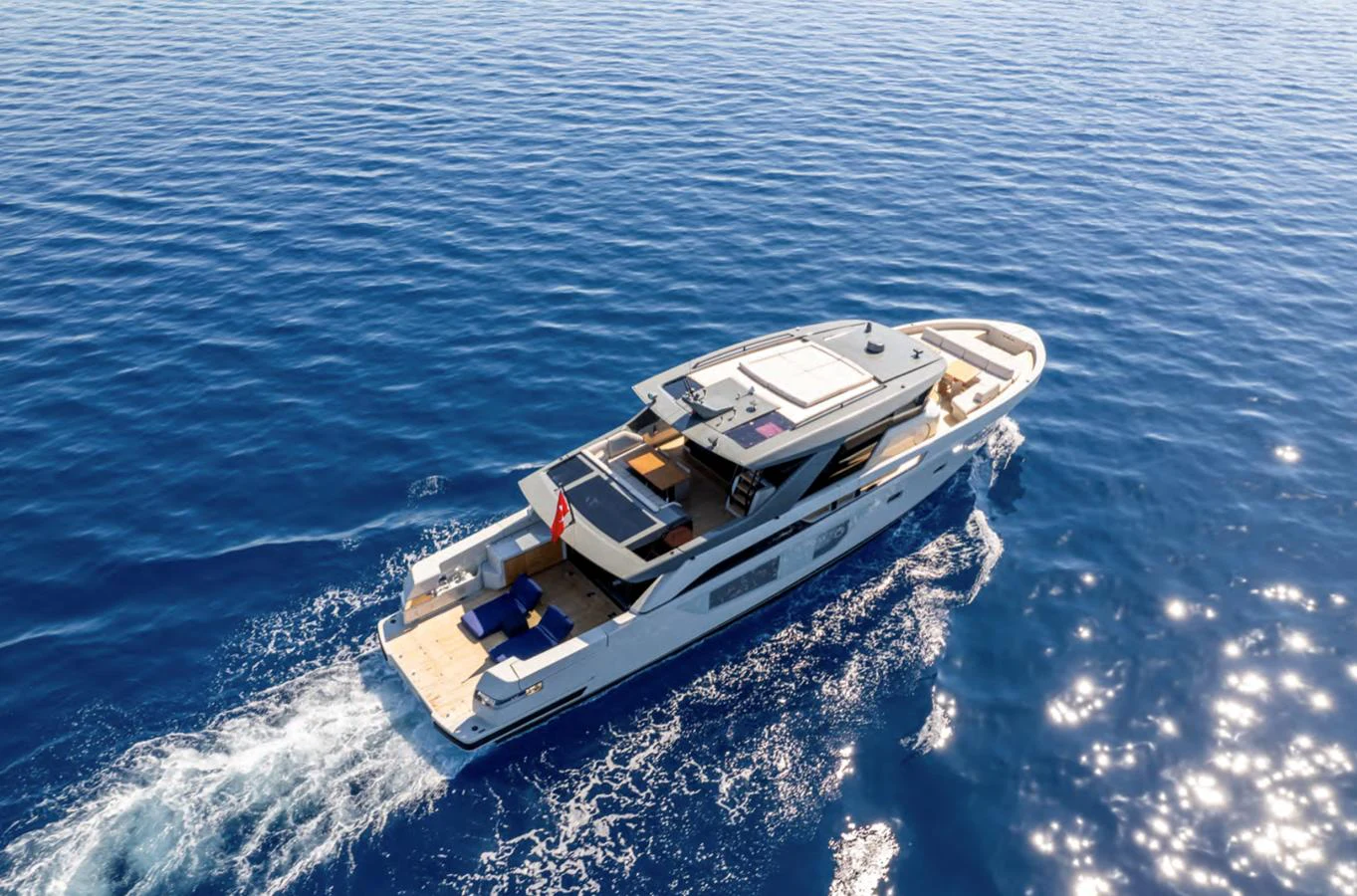 A sleek and modern yacht cruises through clear blue waters, showcasing its elegant design and spacious decks. aboard OUT OF THE BLUE Yacht for Sale