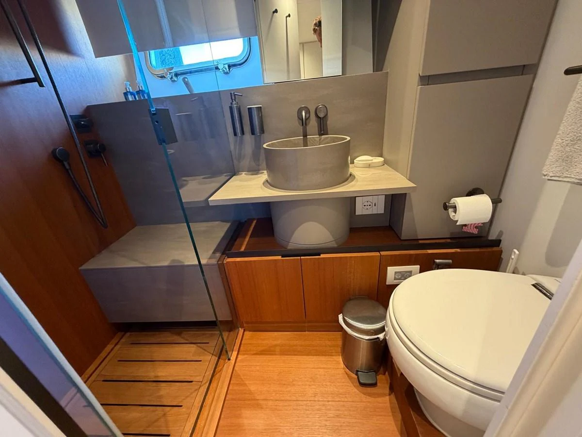 A modern yacht bathroom featuring a sleek sink, shower, and toilet. aboard OUT OF THE BLUE Yacht for Sale
