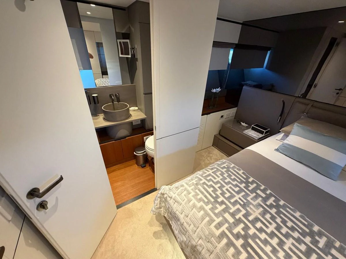 A luxurious stateroom featuring a cozy bed and a modern ensuite bathroom. aboard OUT OF THE BLUE Yacht for Sale