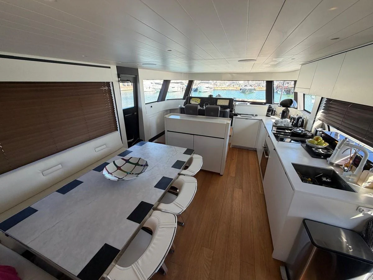 The modern galley and dining area offer a sleek and functional space with ample natural light. aboard OUT OF THE BLUE Yacht for Sale