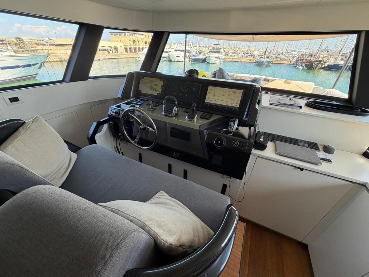 The helm station offers a commanding view of the marina with modern navigation equipment and comfortable seating. aboard OUT OF THE BLUE Yacht for Sale