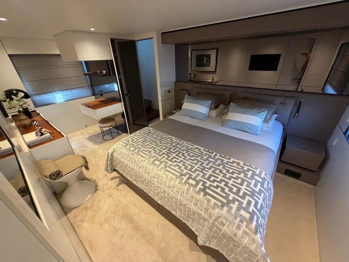 The stateroom features a plush bed with elegant bedding and a cozy seating area, creating a serene retreat. aboard OUT OF THE BLUE Yacht for Sale