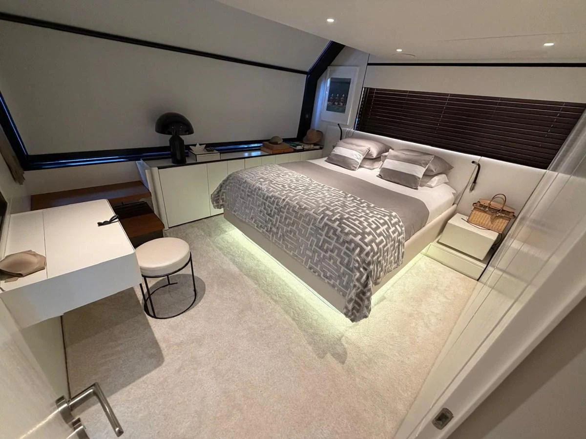 The stateroom features a luxurious bed with modern decor and ample natural light. aboard OUT OF THE BLUE Yacht for Sale