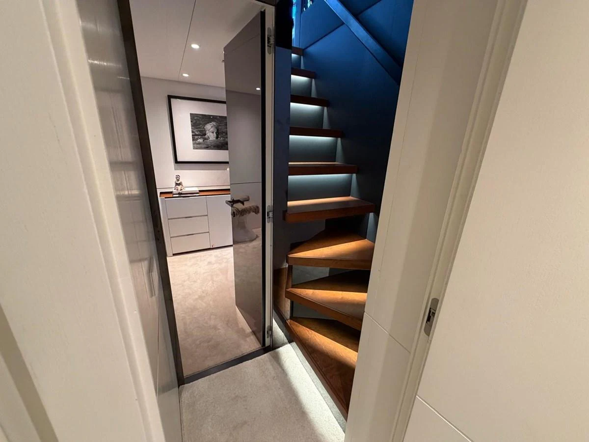 A modern yacht interior featuring a sleek staircase leading to an upper deck. aboard OUT OF THE BLUE Yacht for Sale