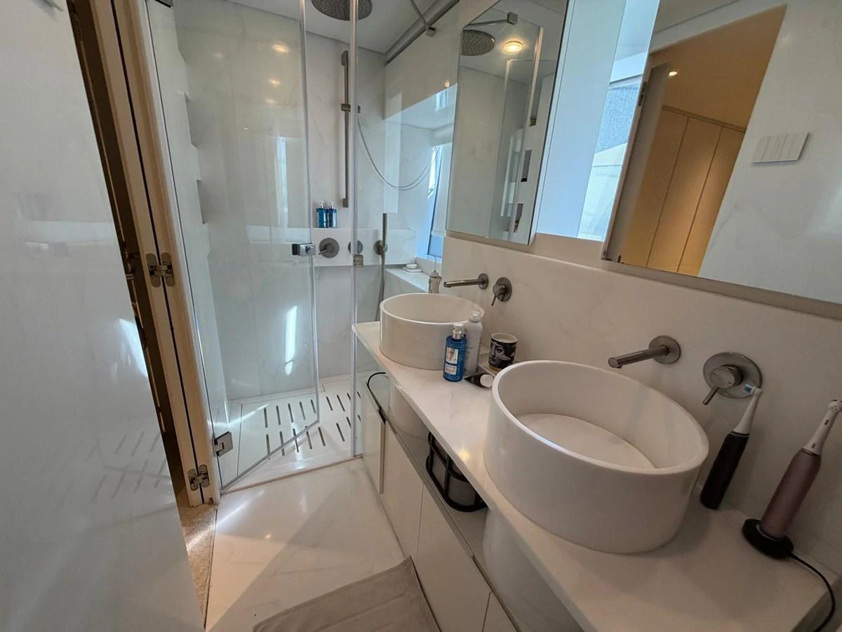 A sleek and modern yacht bathroom featuring dual sinks and a spacious shower. aboard OUT OF THE BLUE Yacht for Sale