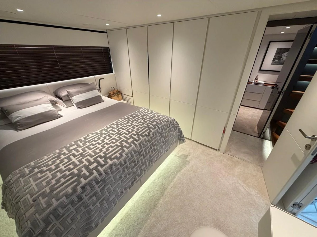 The stateroom features a plush bed with modern bedding and ample storage space. aboard OUT OF THE BLUE Yacht for Sale