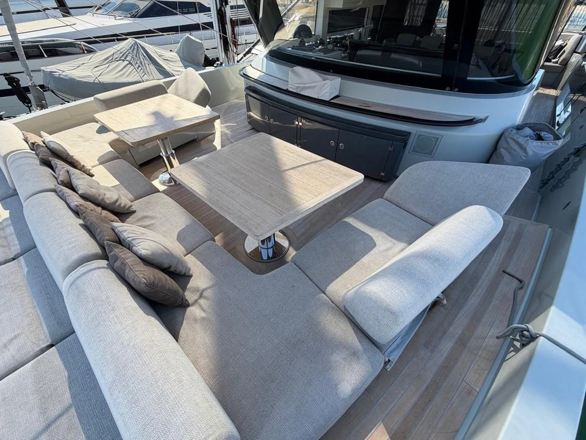 The aft deck features a spacious seating area with comfortable cushions and two tables, perfect for outdoor relaxation. aboard OUT OF THE BLUE Yacht for Sale