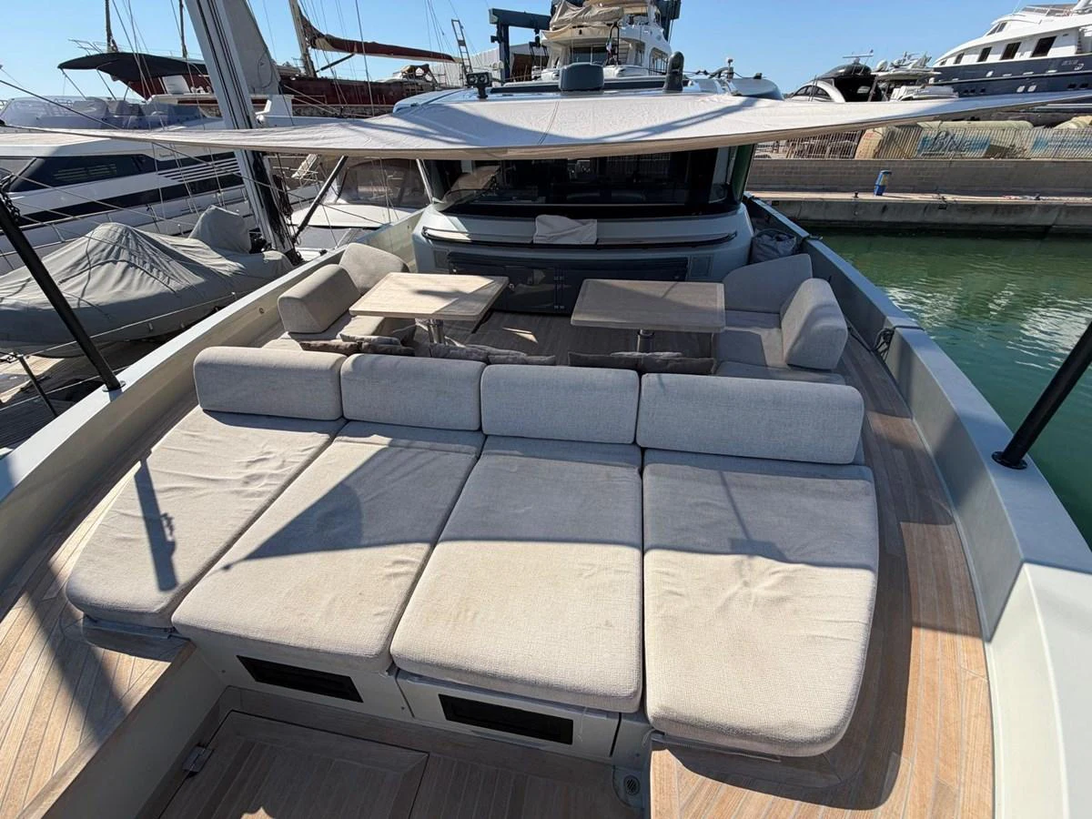 The aft deck features a spacious sunbathing area with plush cushions and a shaded dining space. aboard OUT OF THE BLUE Yacht for Sale