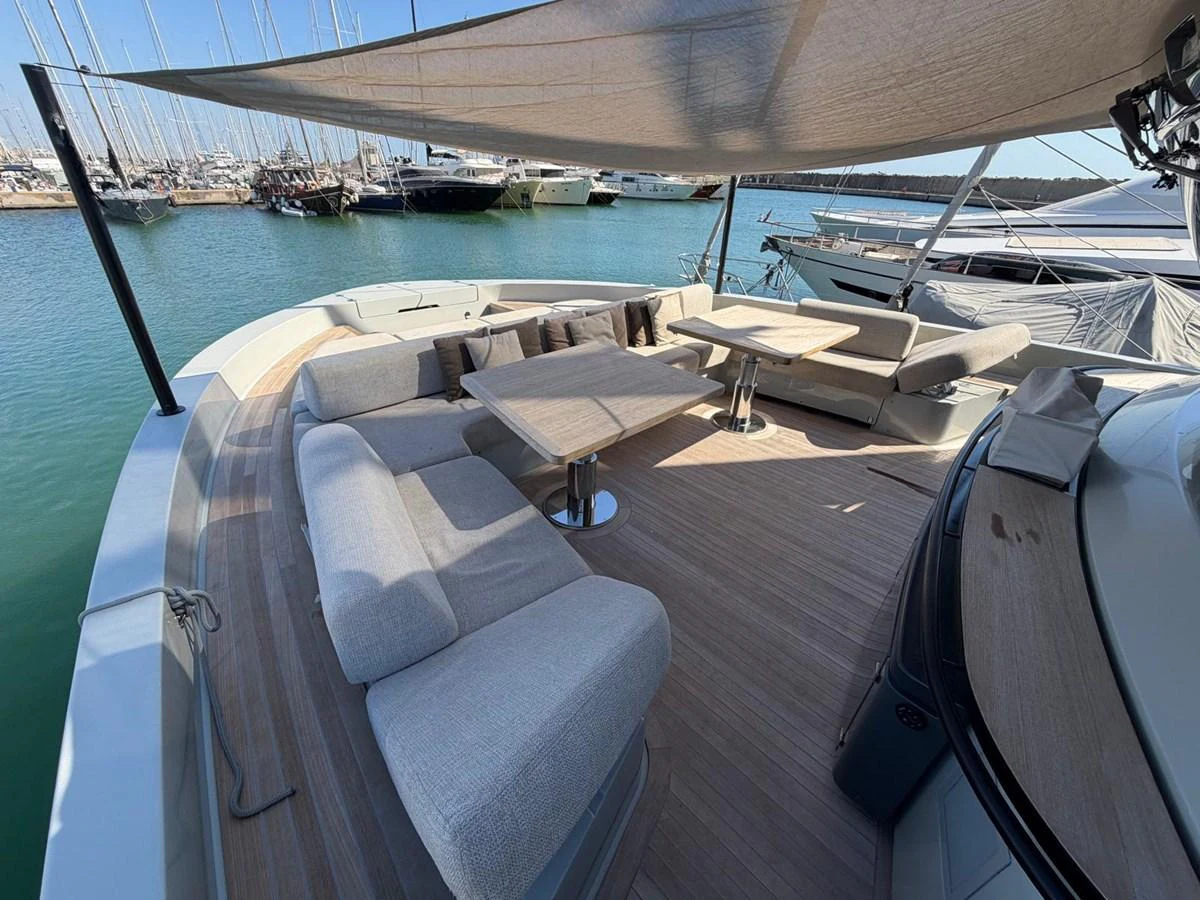 The aft deck features a spacious seating area with plush cushions and a central table, perfect for outdoor relaxation and dining. aboard OUT OF THE BLUE Yacht for Sale
