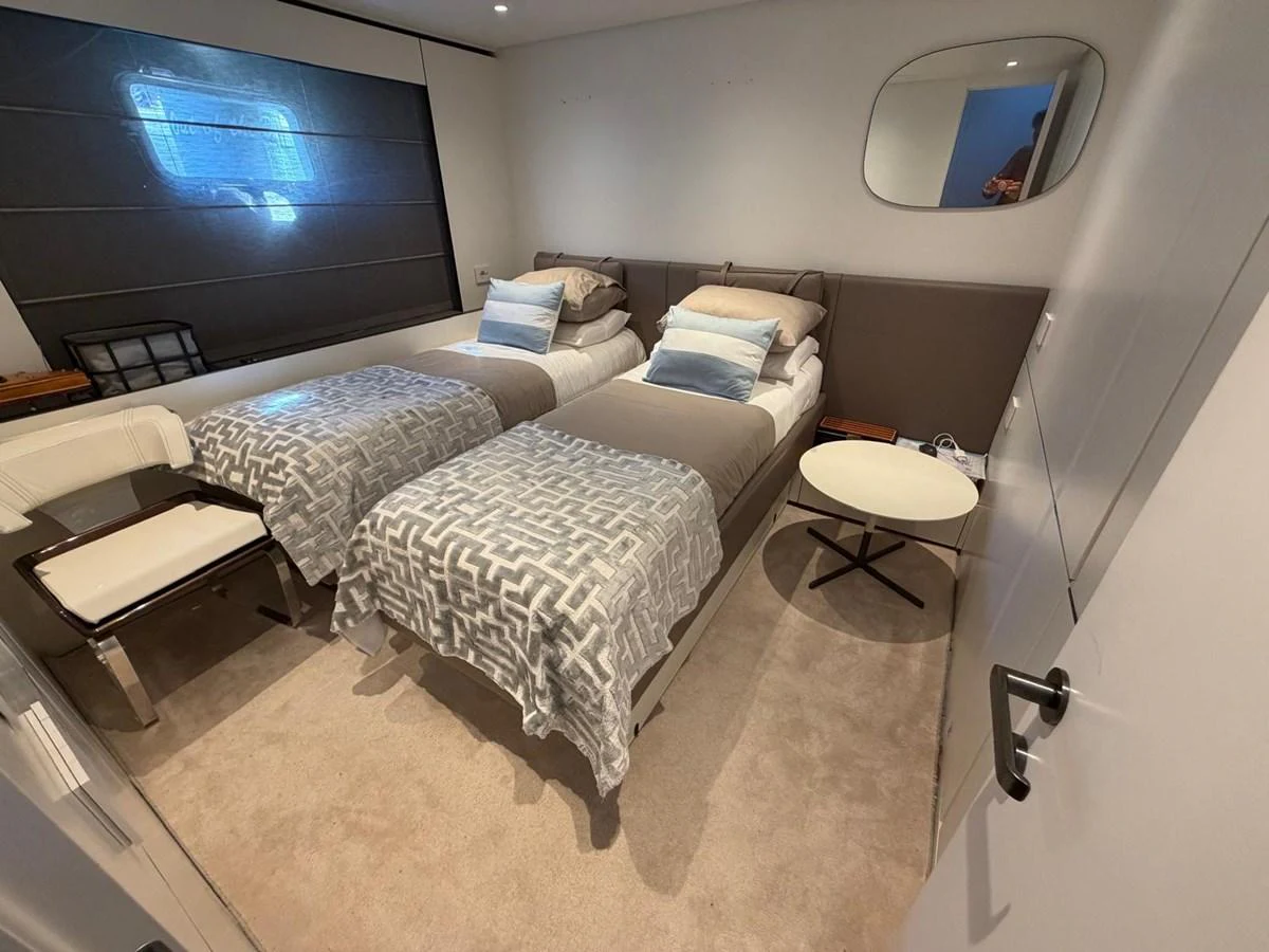 The twin stateroom offers a cozy and modern sleeping area with two single beds and stylish decor. aboard OUT OF THE BLUE Yacht for Sale