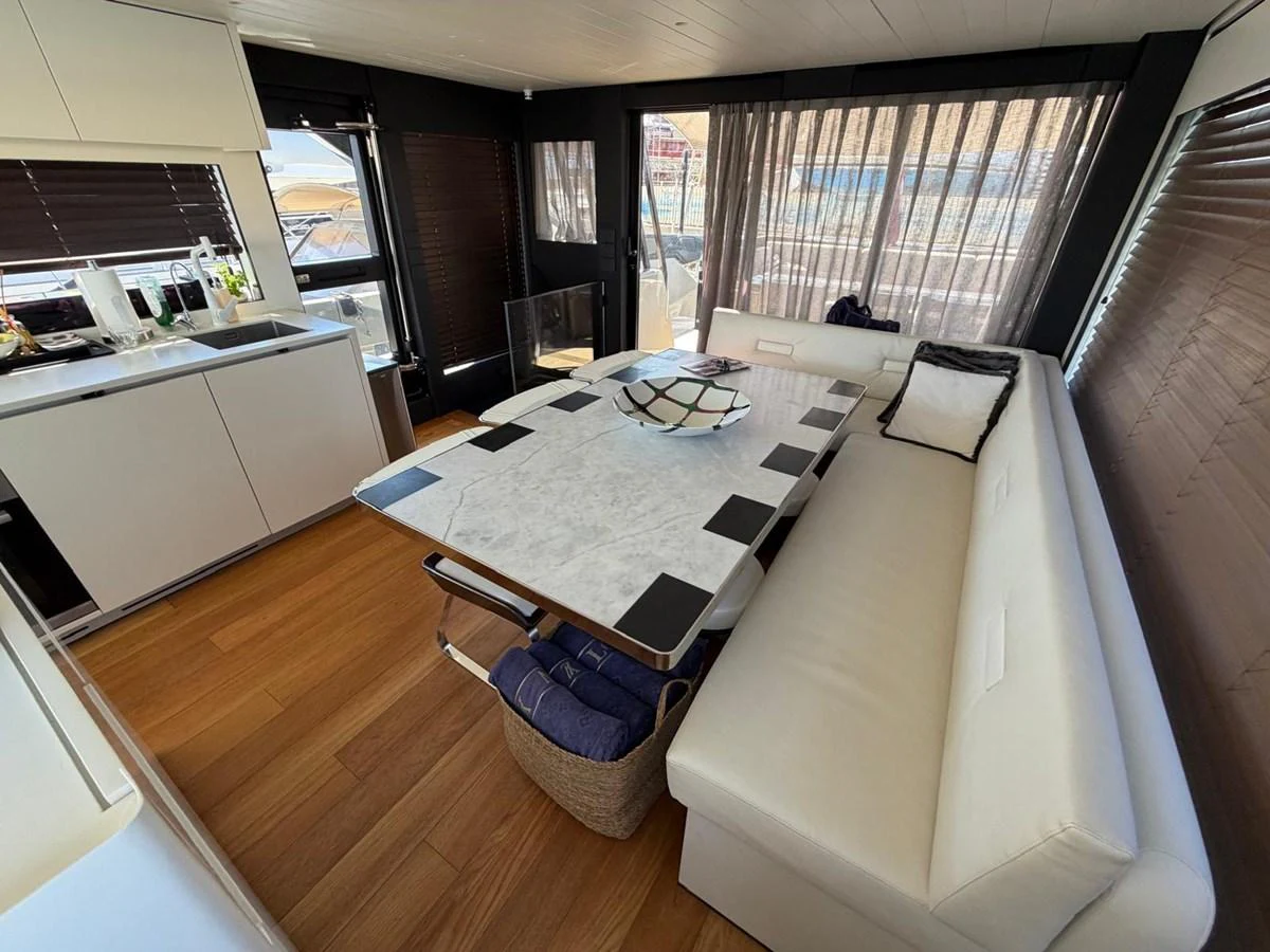 The yacht's salon features a modern dining area with a marble table and comfortable seating. aboard OUT OF THE BLUE Yacht for Sale