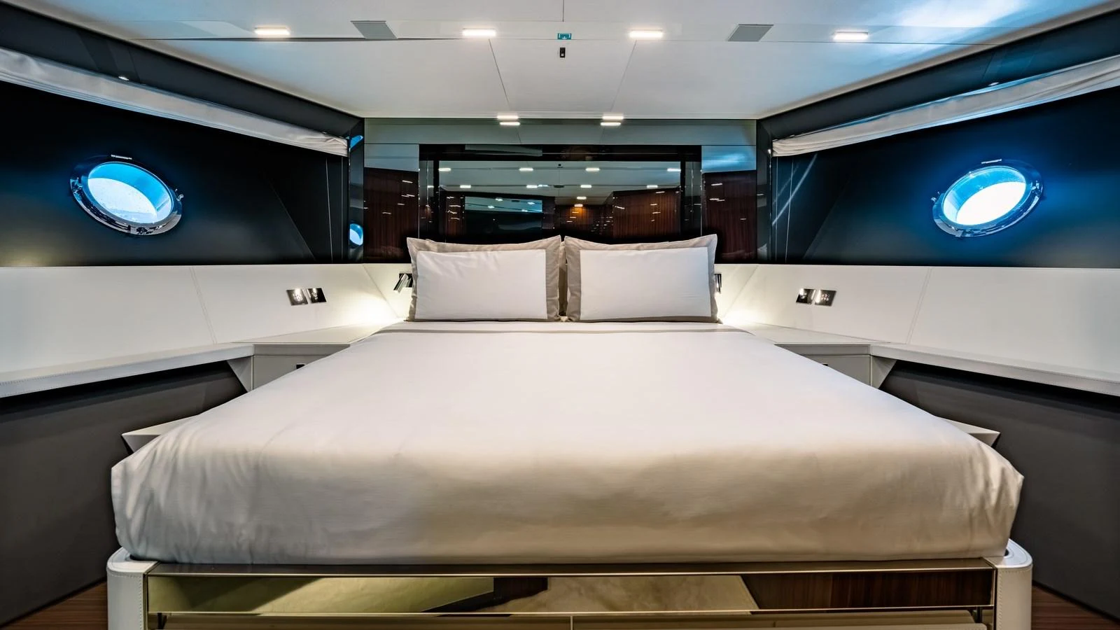 The master stateroom features a luxurious bed with modern lighting and porthole windows. aboard MAYAR Yacht for Sale