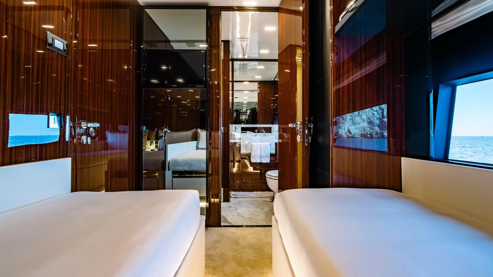 This luxurious stateroom features twin beds and elegant wood paneling with a view of the sea. aboard MAYAR Yacht for Sale