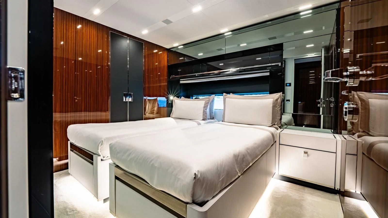 The guest stateroom features twin beds, sleek wood paneling, and modern lighting for a luxurious stay. aboard MAYAR Yacht for Sale