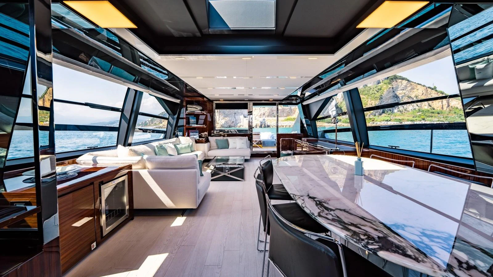 The spacious salon offers panoramic views and luxurious seating with a modern dining area. aboard MAYAR Yacht for Sale