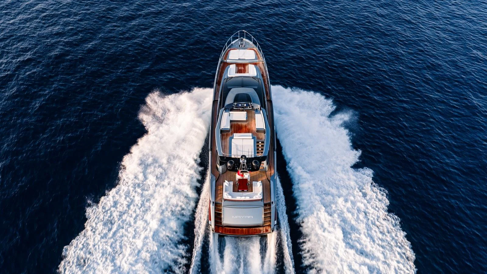 A sleek yacht cruises powerfully through the open sea, leaving a dynamic wake behind. aboard MAYAR Yacht for Sale