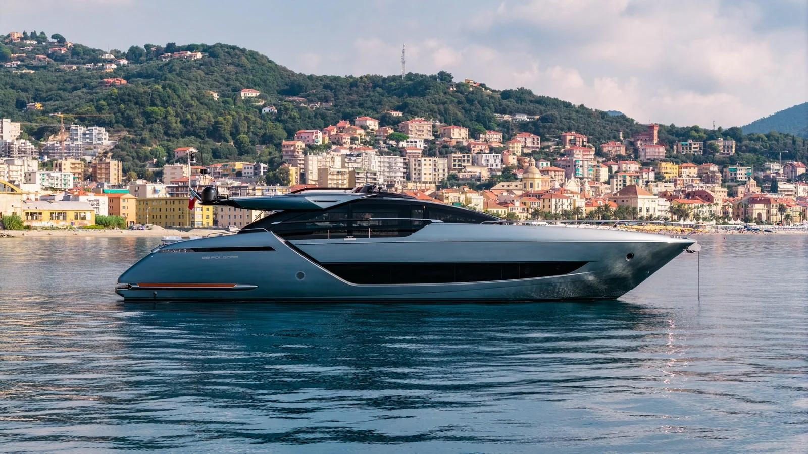 A sleek and modern yacht glides gracefully on calm waters with a picturesque coastal town in the background. aboard MAYAR Yacht for Sale