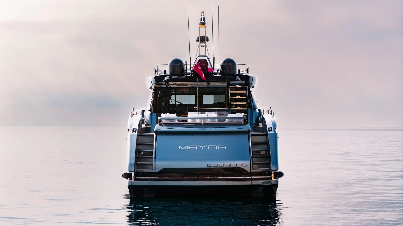 A sleek yacht is captured from the rear, showcasing its modern design and serene presence on the water. aboard MAYAR Yacht for Sale