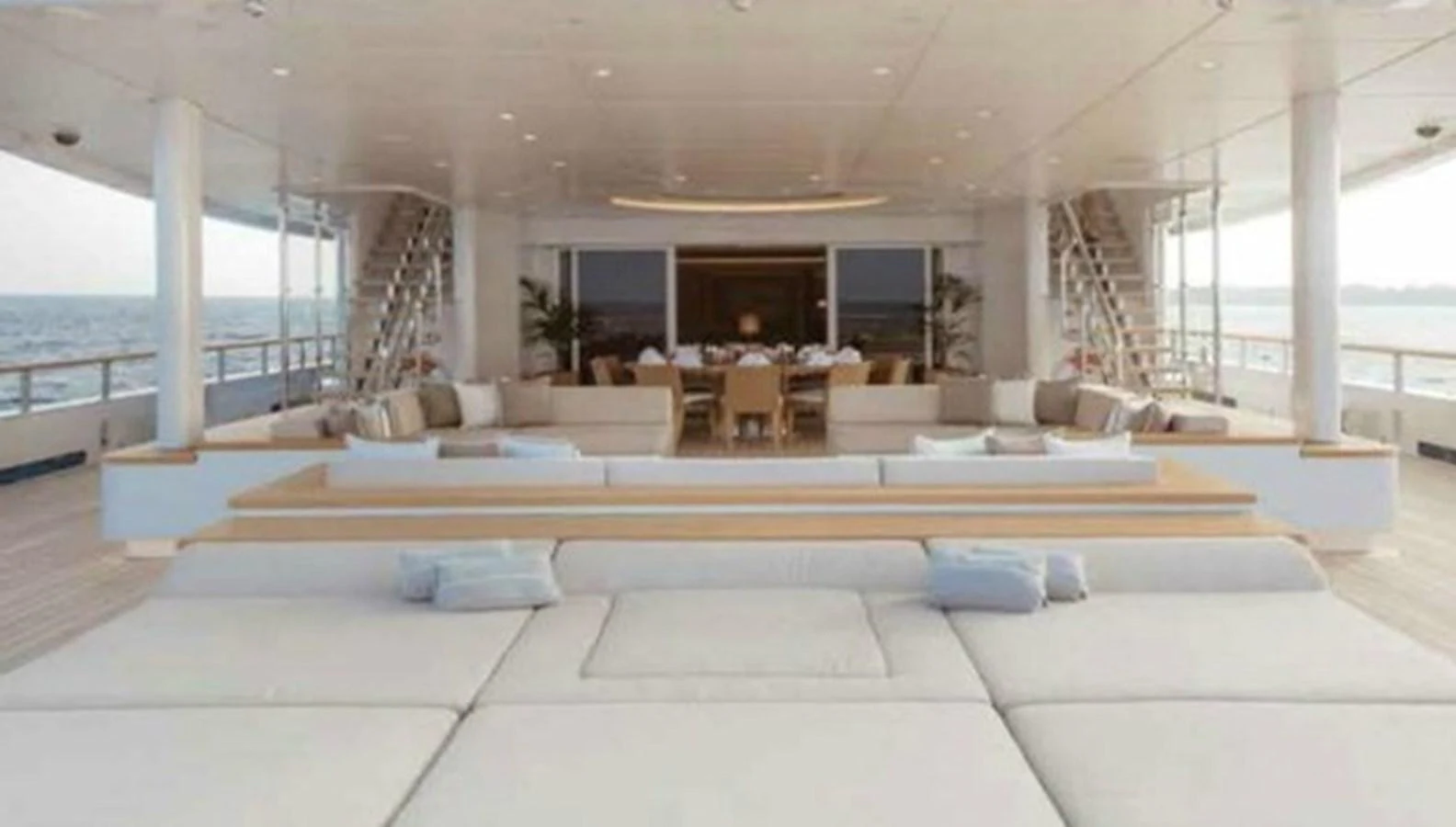 The aft deck features a spacious lounging area with plush seating and a dining table for elegant outdoor meals. aboard DYTAN Yacht for Sale