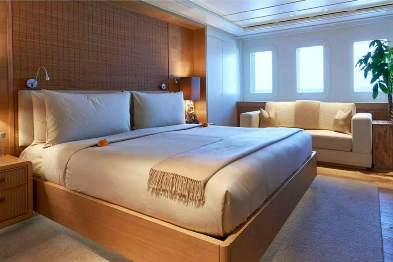 The master stateroom features a spacious bed, a cozy sofa, and ample natural light from the windows. aboard DYTAN Yacht for Sale