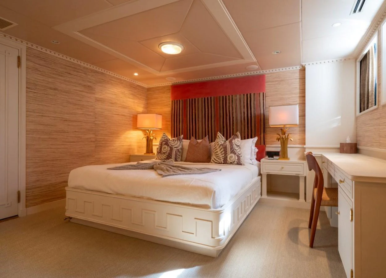 The stateroom features a luxurious bed with elegant decor and ample natural light. aboard STELLA FIERA II Yacht for Sale