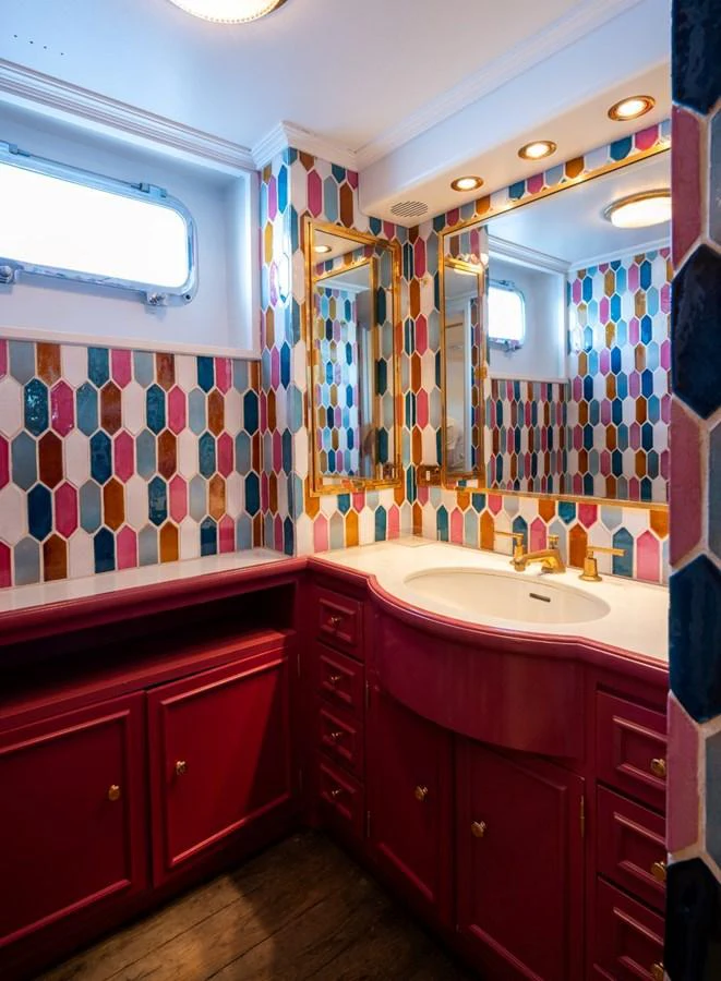 A vibrant yacht bathroom with colorful tile walls and a stylish vanity. aboard STELLA FIERA II Yacht for Sale