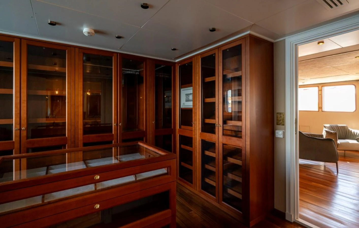 The yacht's interior features a sophisticated library with ample wooden shelving and a cozy seating area nearby. aboard STELLA FIERA II Yacht for Sale