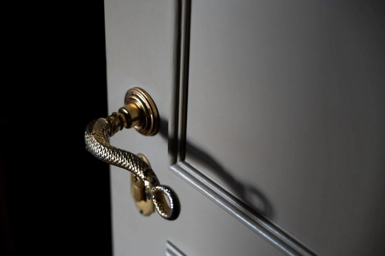 A close-up of an elegant, gold-toned door handle with intricate design on a yacht. aboard STELLA FIERA II Yacht for Sale