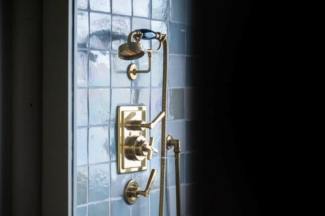 A luxurious gold-finished shower fixture set against a stylish tiled wall. aboard STELLA FIERA II Yacht for Sale
