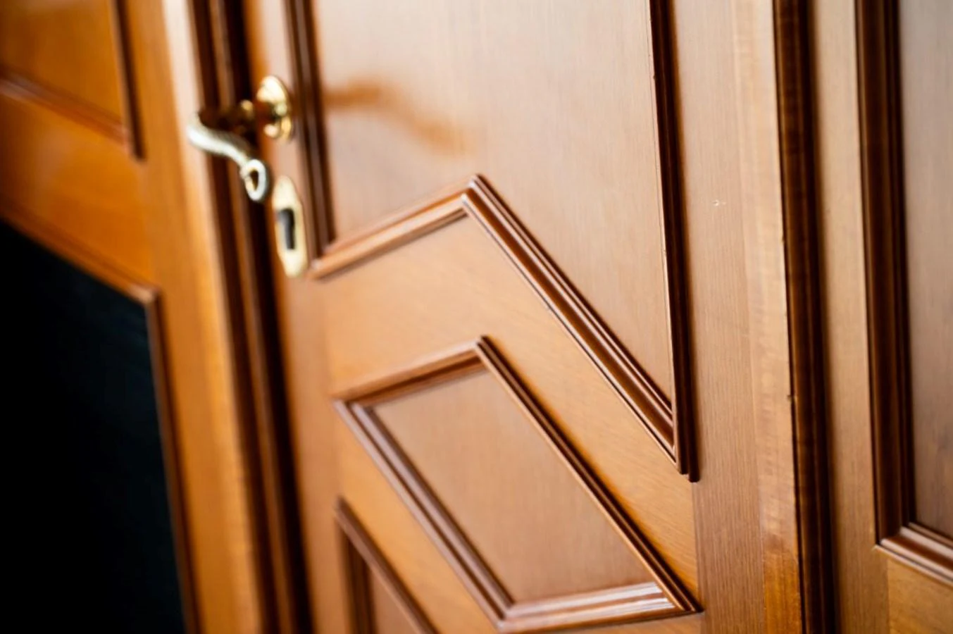 A close-up view of the yacht's elegant wooden door with intricate paneling and a polished brass handle. aboard STELLA FIERA II Yacht for Sale