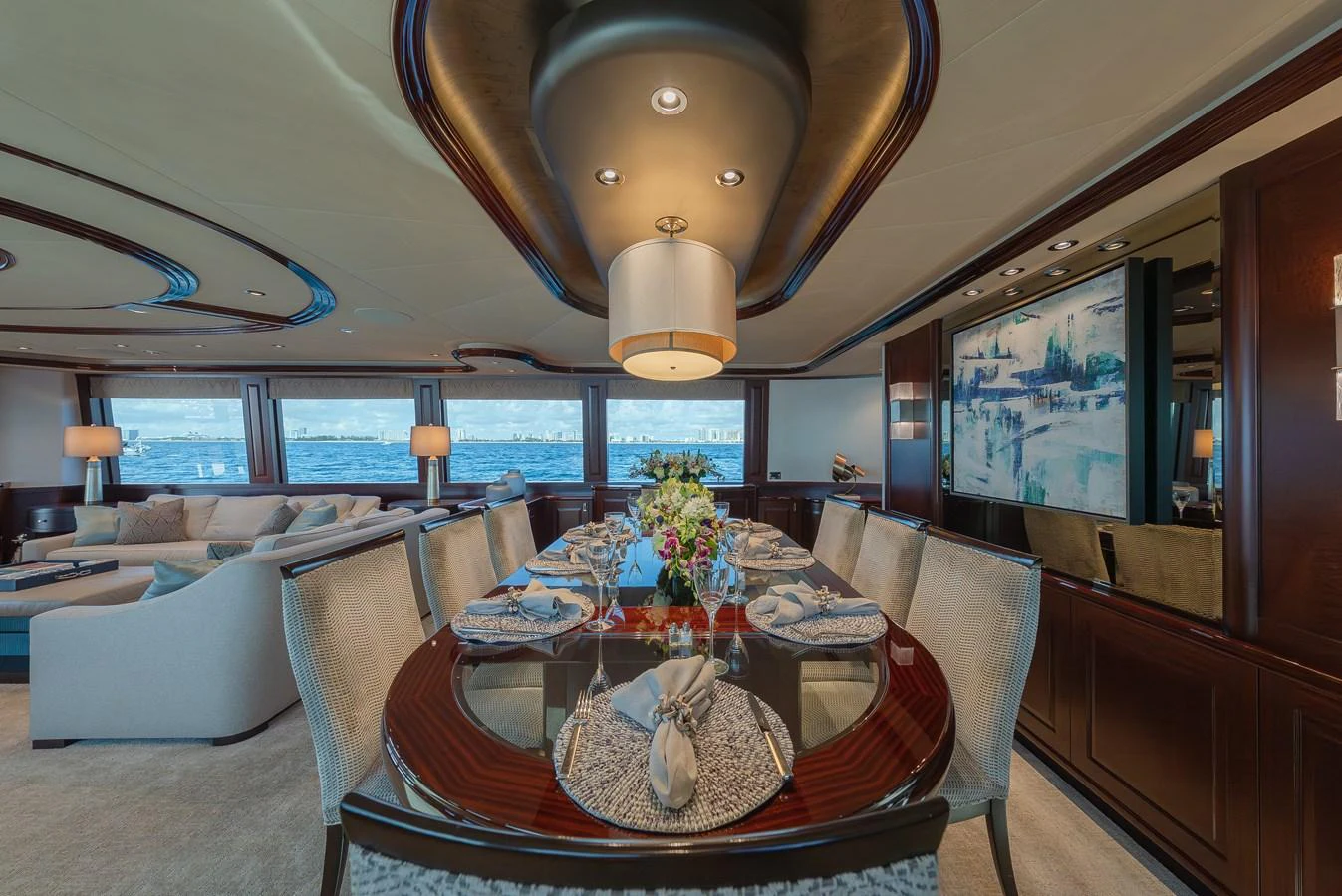 The yacht's dining area features an elegant table setting with panoramic ocean views. aboard DETERMINATION Yacht for Sale