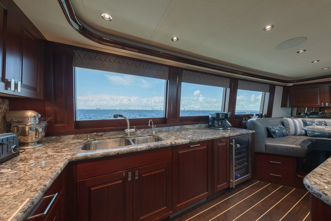 The galley features rich wood cabinetry, granite countertops, and large windows offering stunning sea views. aboard DETERMINATION Yacht for Sale