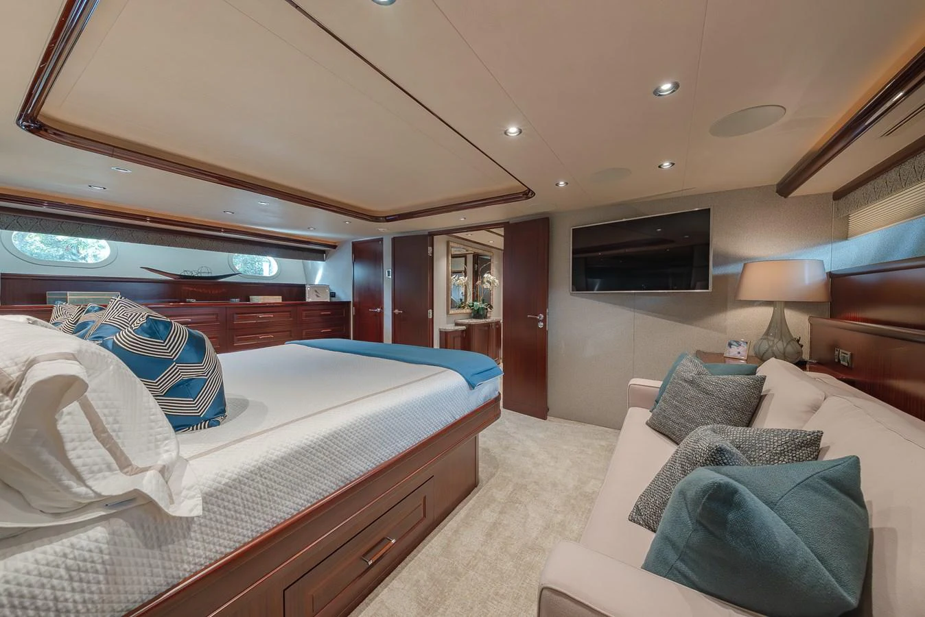 The master stateroom features a luxurious bed, a comfortable seating area, and elegant wood finishes. aboard DETERMINATION Yacht for Sale