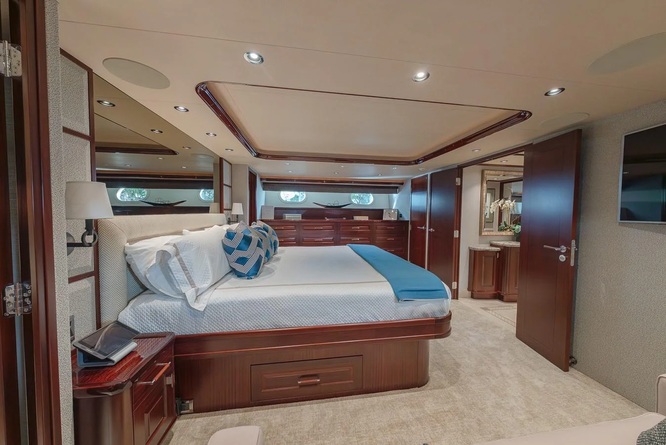 The master stateroom features a spacious bed with elegant wood finishes and modern lighting. aboard DETERMINATION Yacht for Sale