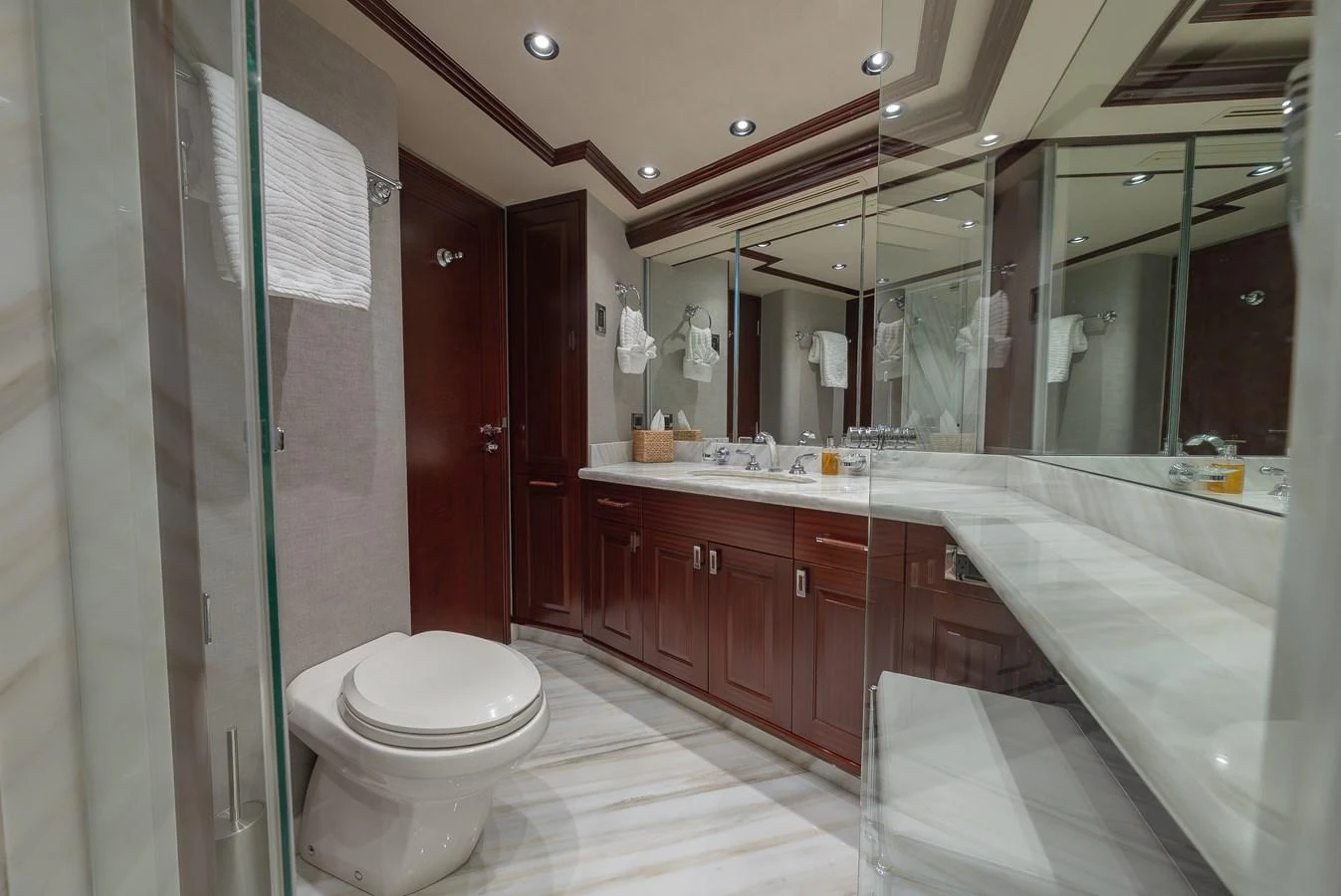The yacht's bathroom features elegant wood cabinetry, a spacious countertop, and modern fixtures. aboard DETERMINATION Yacht for Sale