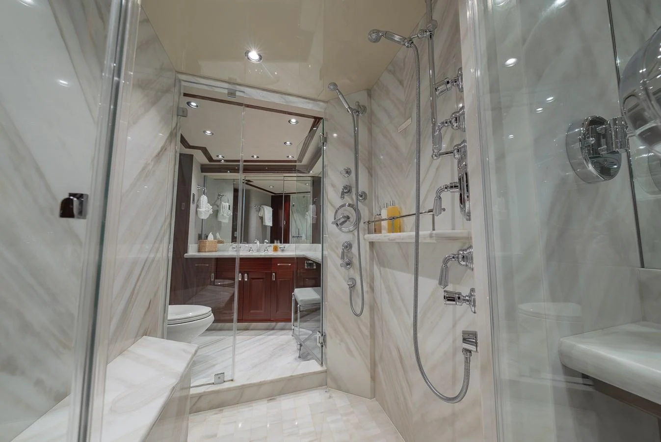 The luxurious bathroom features elegant marble walls and high-end fixtures. aboard DETERMINATION Yacht for Sale