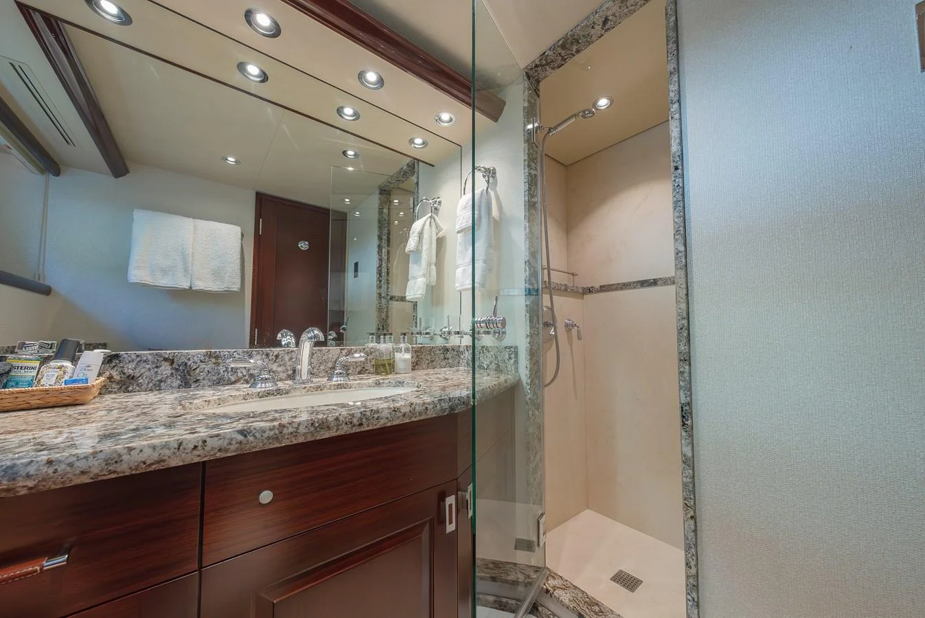 The yacht's bathroom features a sleek design with a granite countertop and a spacious shower area. aboard DETERMINATION Yacht for Sale