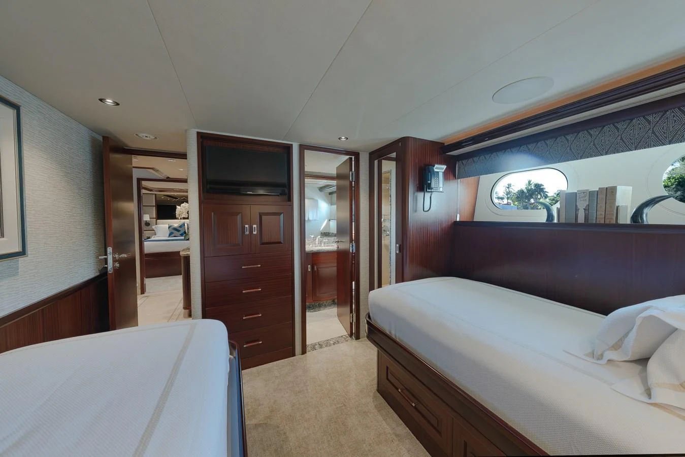The guest stateroom features twin beds, rich wood finishes, and ample storage. aboard DETERMINATION Yacht for Sale