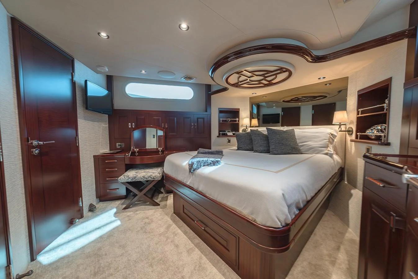The master stateroom features a luxurious bed with elegant wood finishes and modern amenities. aboard DETERMINATION Yacht for Sale