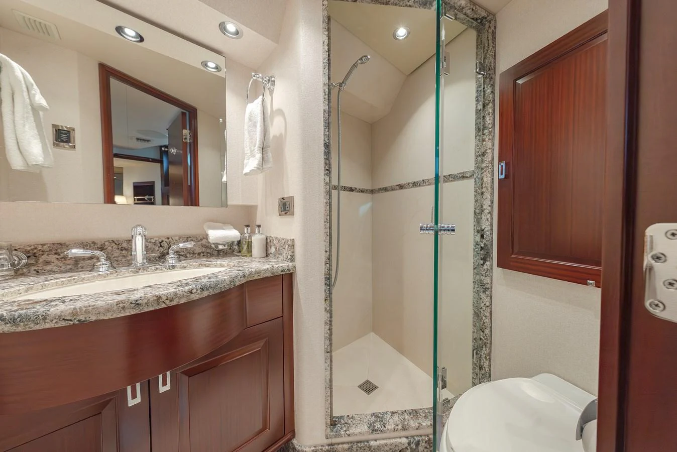 The yacht's bathroom features a sleek design with a glass-enclosed shower and elegant marble countertops. aboard DETERMINATION Yacht for Sale
