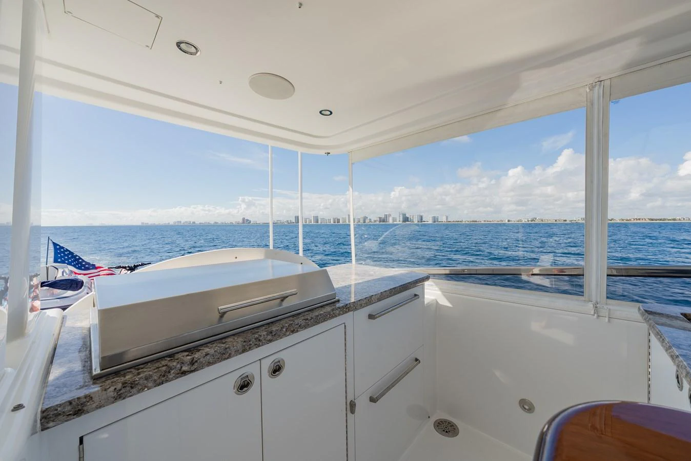 A sleek and modern galley area with a view of the open sea and distant city skyline. aboard DETERMINATION Yacht for Sale