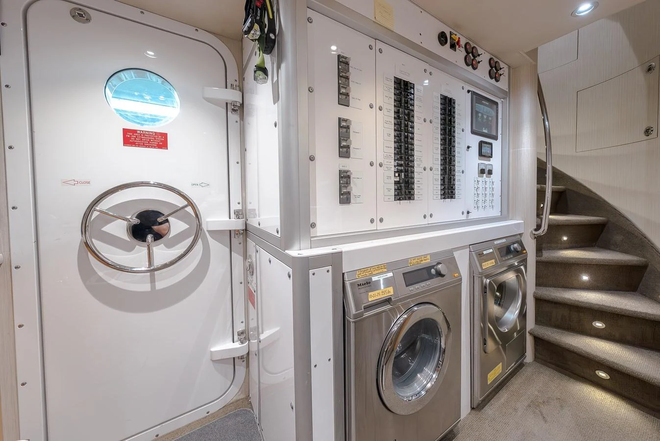 The yacht's laundry room is equipped with modern appliances and essential control panels. aboard DETERMINATION Yacht for Sale