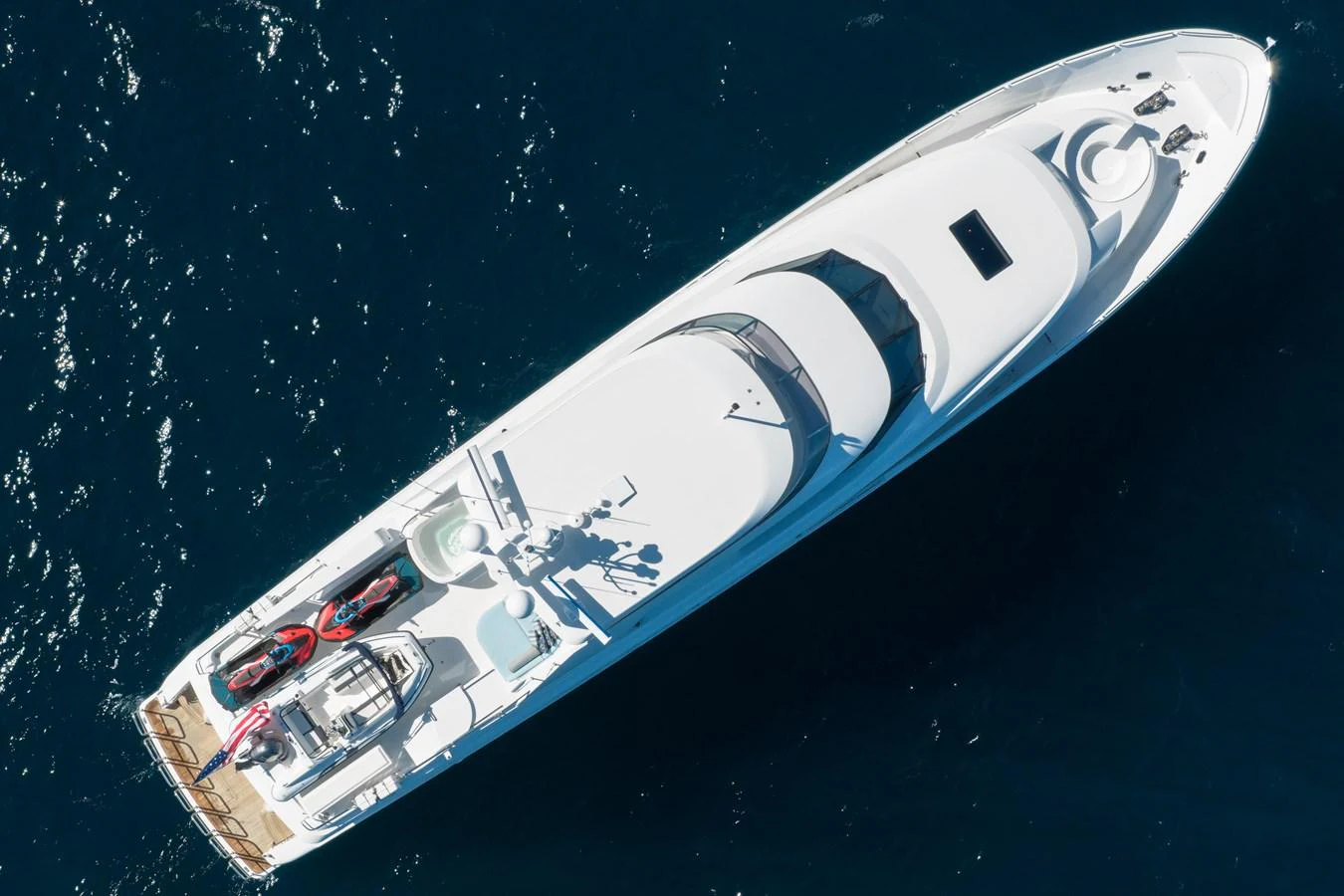 A sleek yacht is captured from above, showcasing its streamlined design and spacious deck. aboard DETERMINATION Yacht for Sale