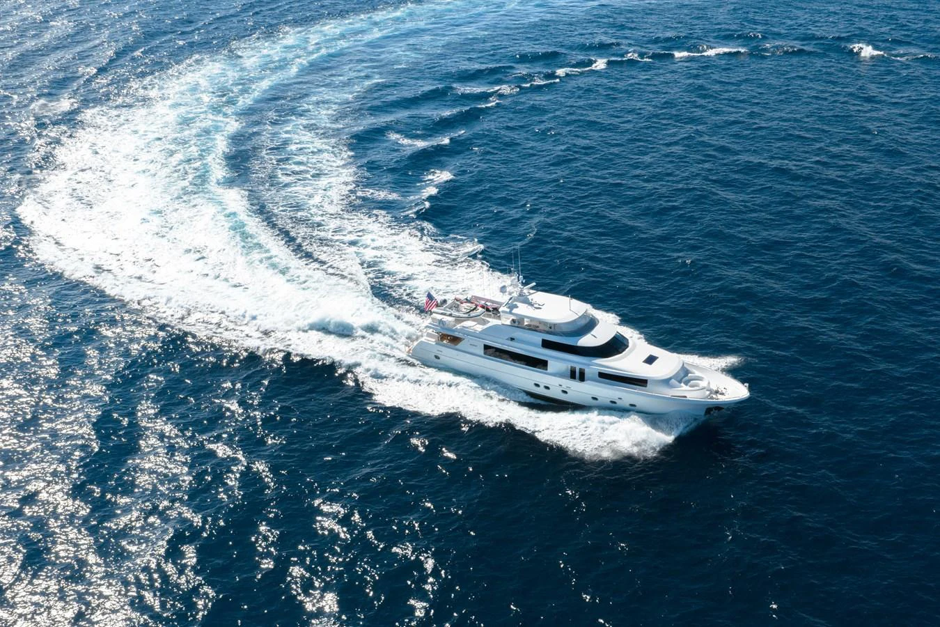 A luxurious yacht glides gracefully through the open sea, leaving a trail of white foam in its wake. aboard DETERMINATION Yacht for Sale