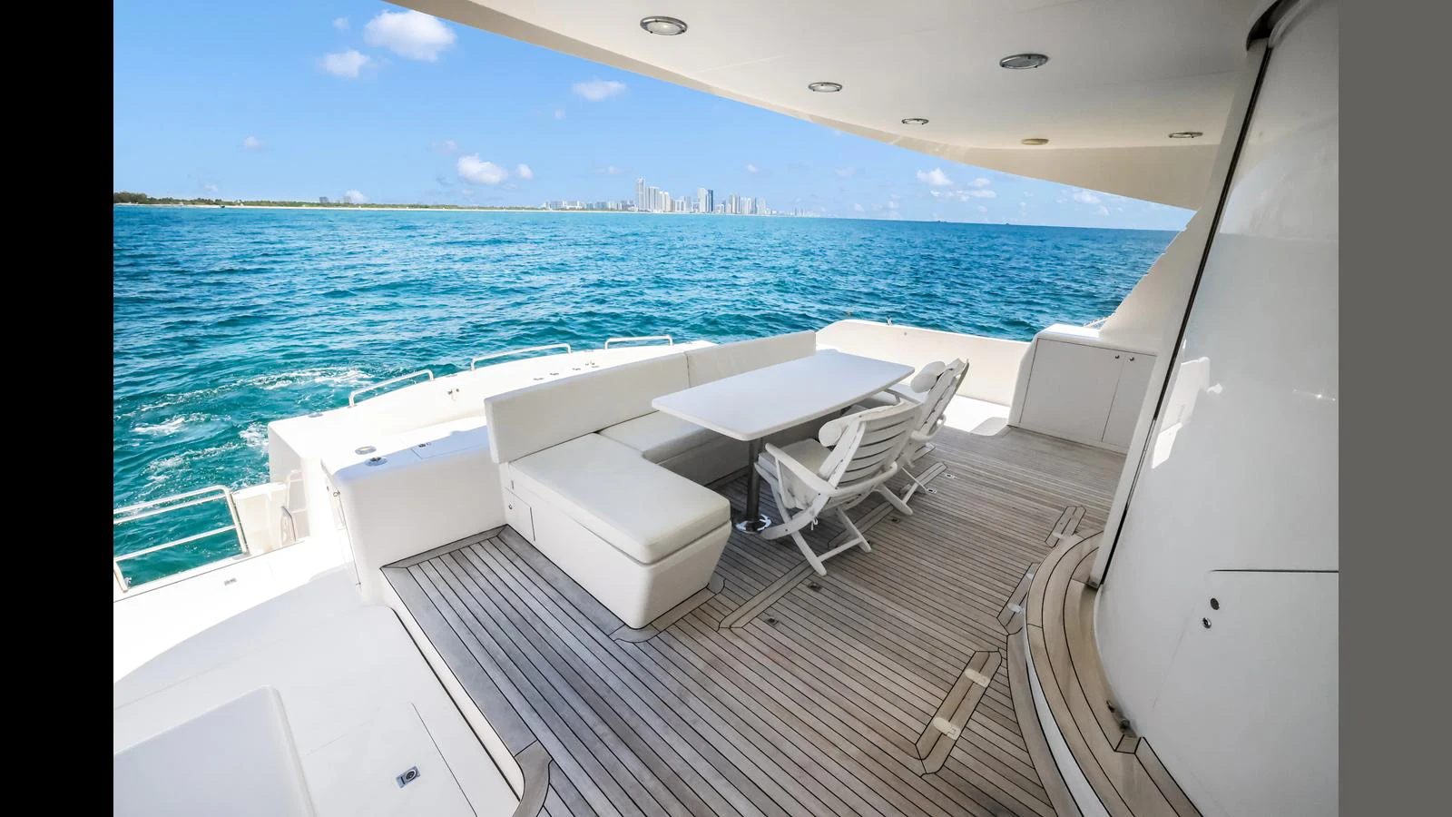 The aft deck features a spacious seating area with a table, perfect for alfresco dining with stunning ocean views. aboard MOANA Yacht for Sale