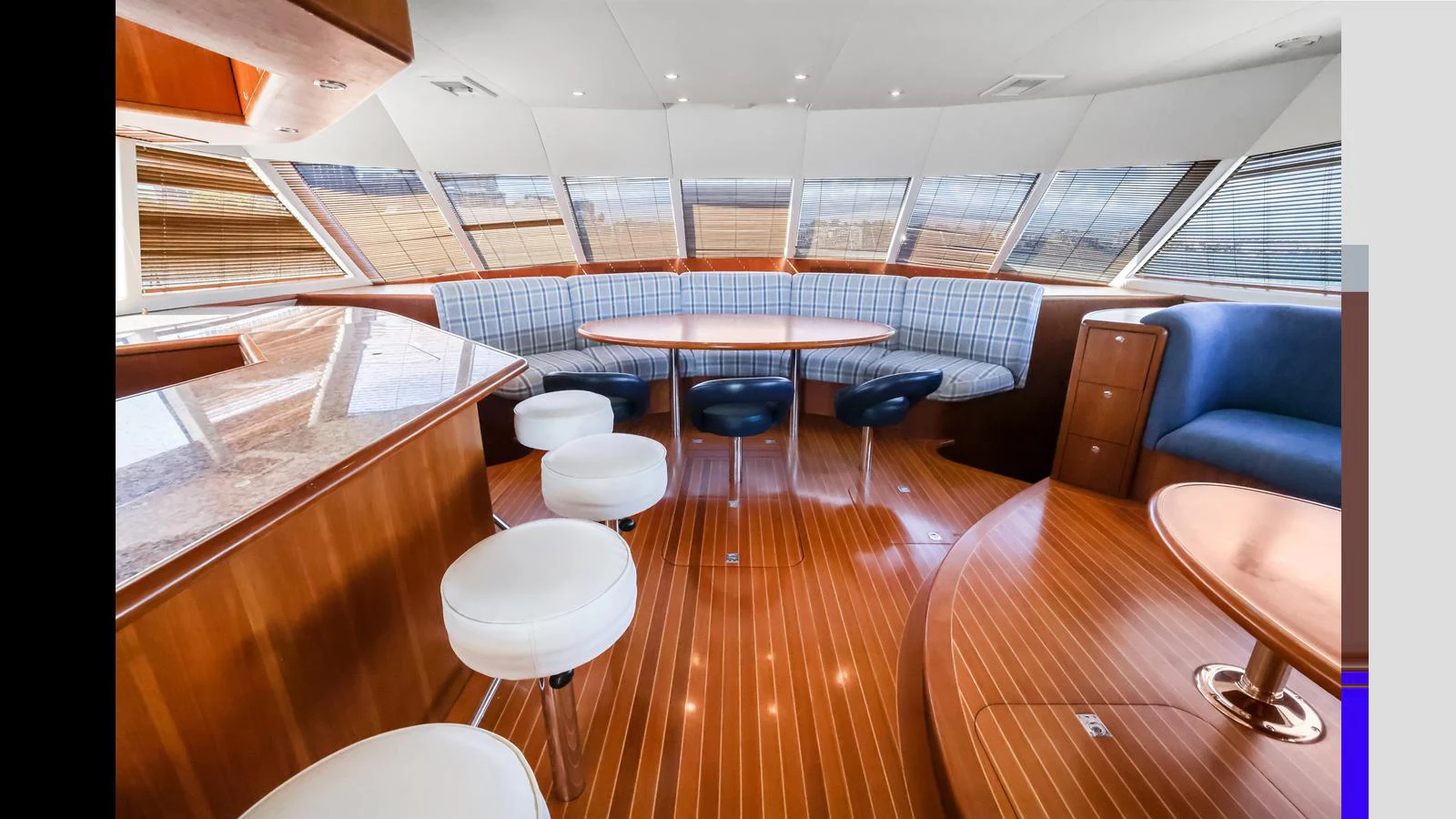 The yacht's interior features a spacious seating area with a blend of wooden and upholstered finishes, creating a warm and inviting atmosphere. aboard MOANA Yacht for Sale
