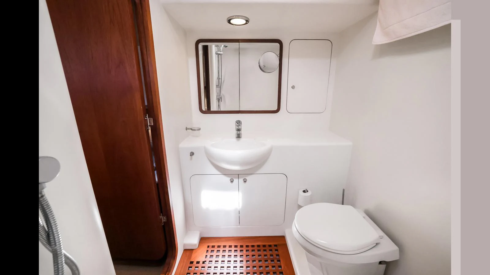 The yacht's head features a modern sink, toilet, and shower with clean, white finishes. aboard MOANA Yacht for Sale