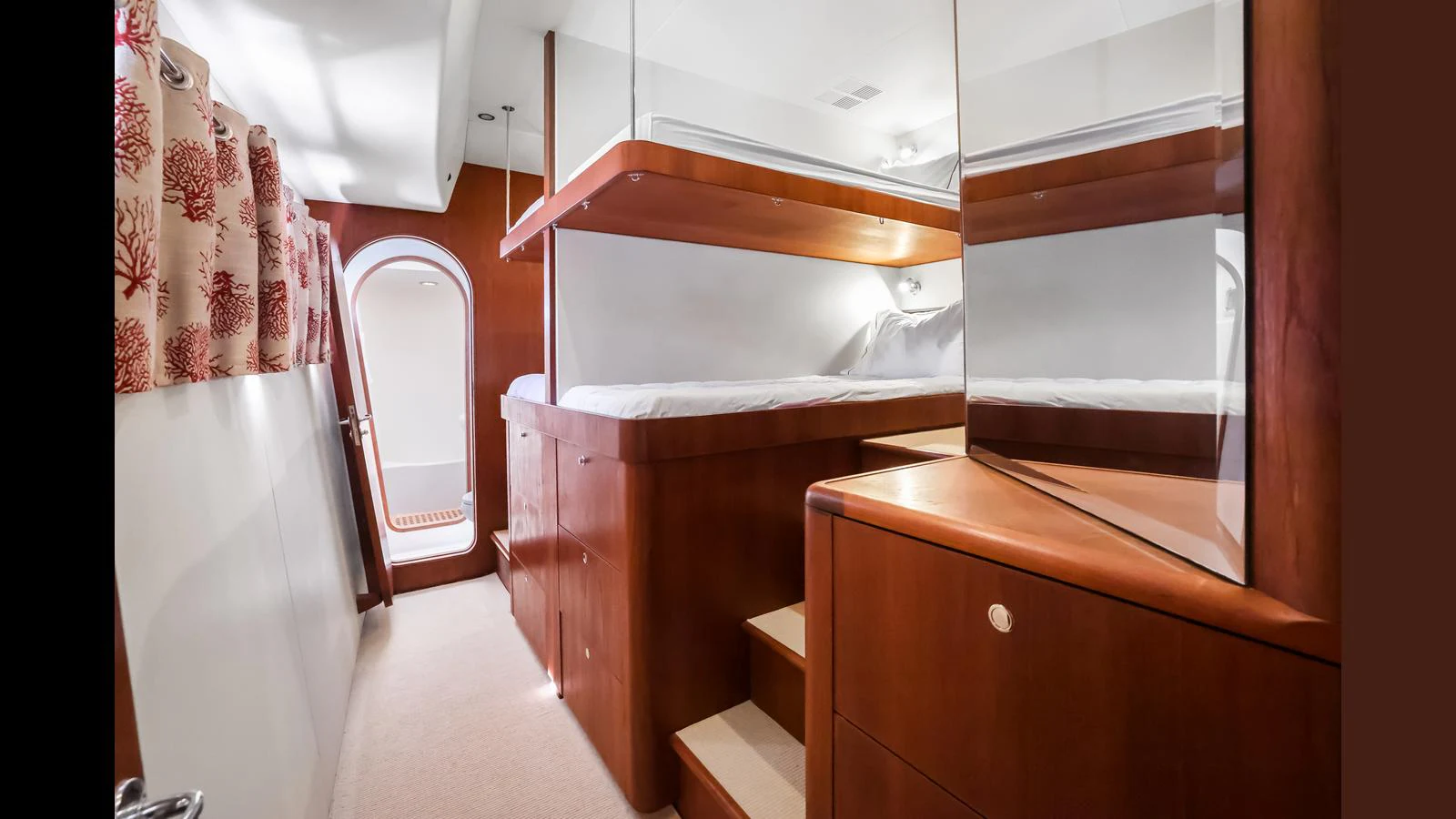 The cozy cabin features a double bunk bed setup with warm wooden finishes and soft lighting. aboard MOANA Yacht for Sale