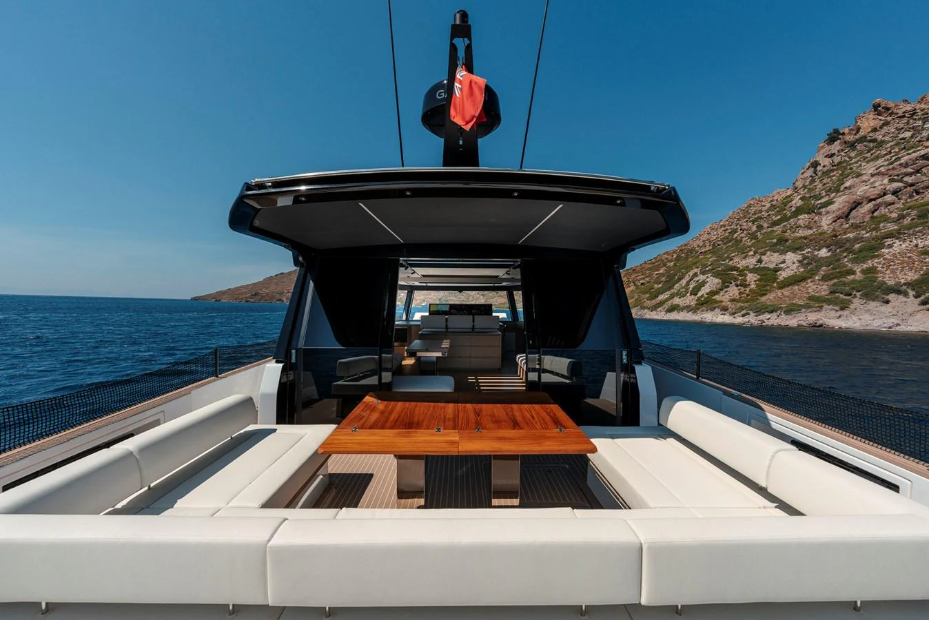 The aft deck offers a spacious and luxurious seating area with a central wooden table, perfect for outdoor relaxation and dining. aboard LUCKY LUKA Yacht for Sale