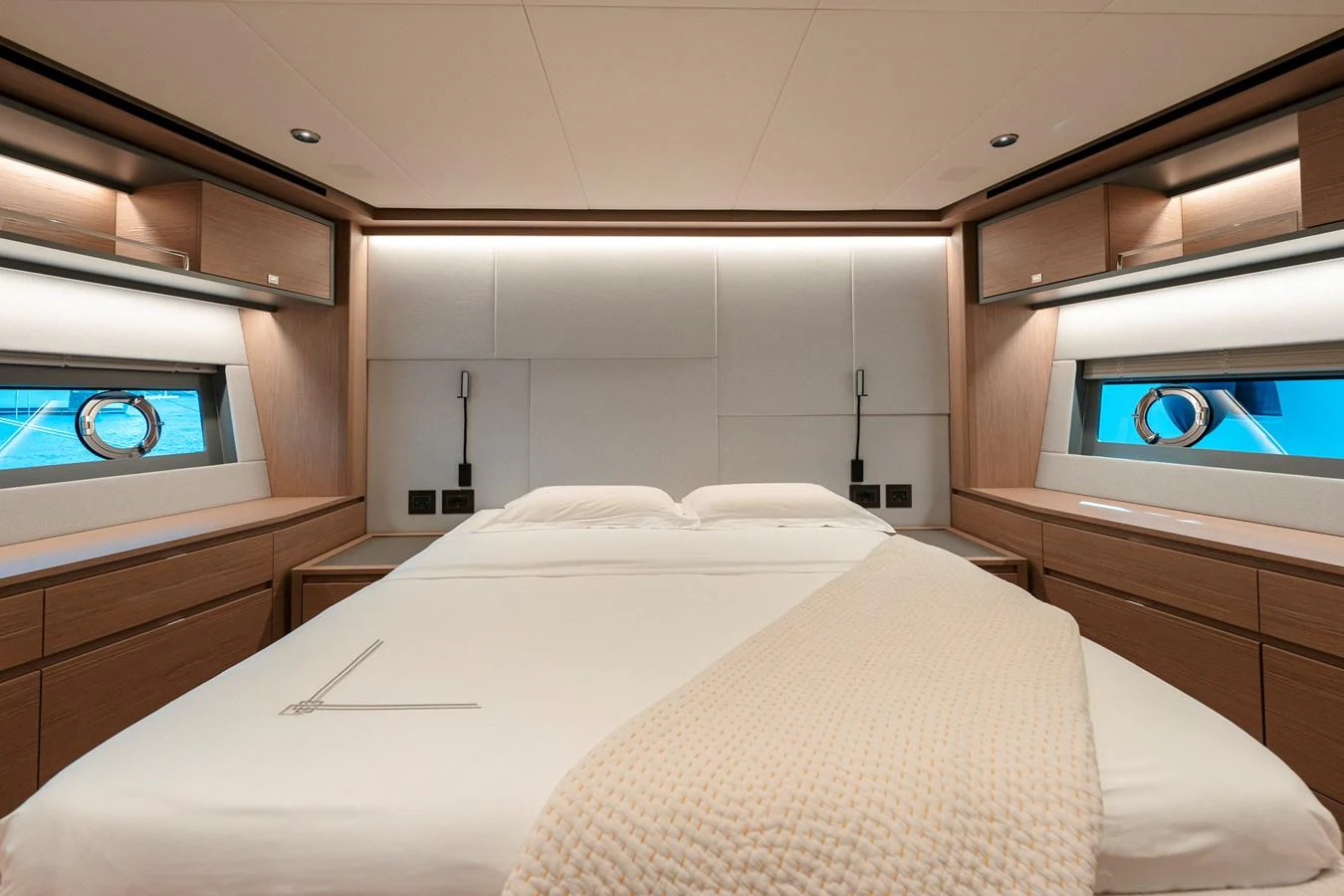 The stateroom features a luxurious bed with modern wooden cabinetry and large windows offering a serene view. aboard LUCKY LUKA Yacht for Sale